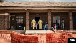 Medical workers lead a young girl with suspected Ebola into the unconfirmed Ebola patients ward run by The Alliance for International Medical Action (ALIMA), Aug. 12, 2018 in Beni, northeastern DRC. 