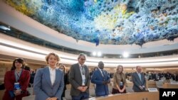 Delegates stands for a minute of silence to mark the 75th anniversary of the Universal Declaration of Human Rights, at the United Nations Offices, in Geneva on December 11, 2023.