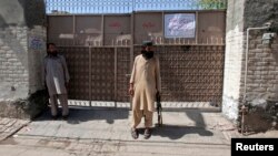 Nhân viên bảo vệ với khẩu AK-47 đứng canh trước cổng nhà của thủ lãnh nhóm Lashkar e-Jhangvi 