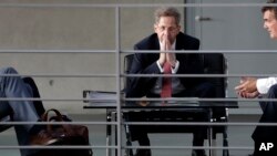 FILE - Hans-Georg Maassen, head of the German Federal Office for the Protection of the Constitution, waits for the beginning of a hearing at the home affairs committee of the German federal parliament, Bundestag, in Berlin, Germany, Sept. 12, 2018. 
