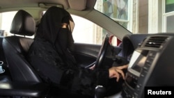 FILE - A woman drives a car in Saudi Arabia, Oct. 22, 2013.