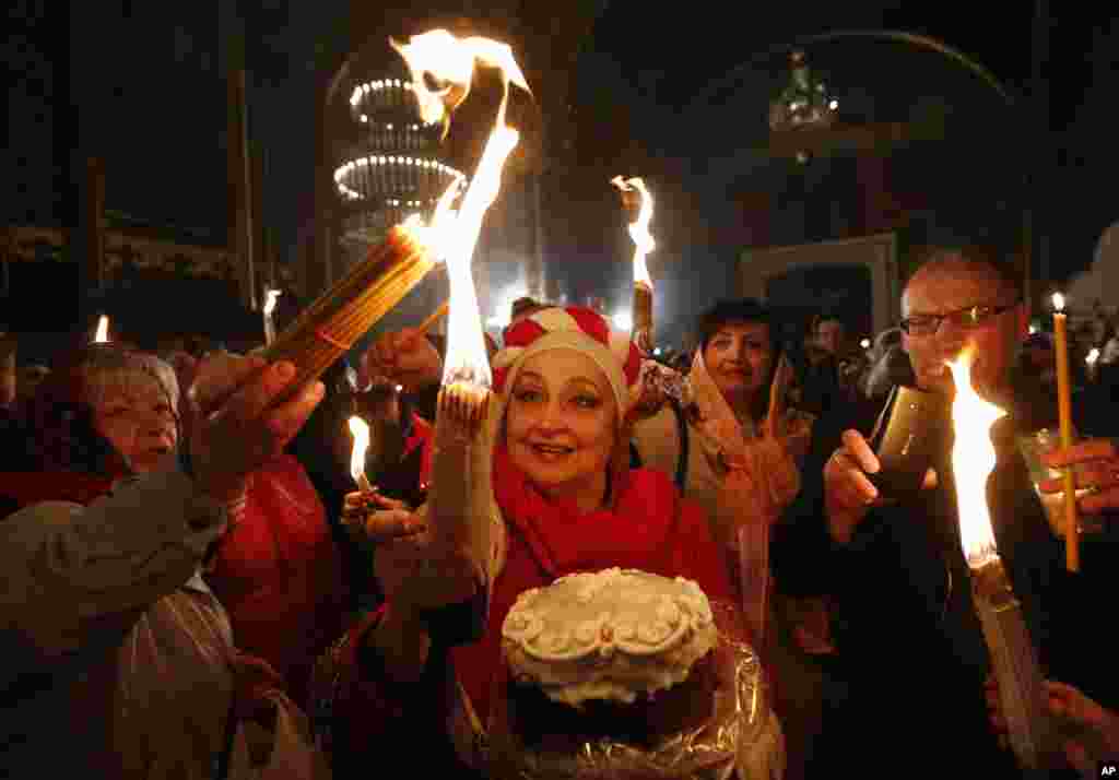 Ukrainian Orthodox faithful light candles from the Holy Fire brought from Jerusalem in St. Volodymyr Cathedral during the ceremony of the Holy Fire in Kyiv, Ukraine, April 15, 2017. The Holy Fire ceremony is part of Orthodox Easter rituals and the flame symbolizes the resurrection of Christ in a ceremony dating back to the 12th century.