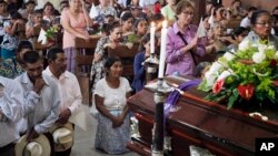 People pray by the coffin of slain Janeth Urquia, an environmentalist and indigenous rights activist, during Mass in Marcala, Honduras, July 8, 2016.