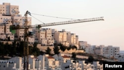 FILE - A crane is seen next to homes in the Har Homa Jewish settlement in Jerusalem.