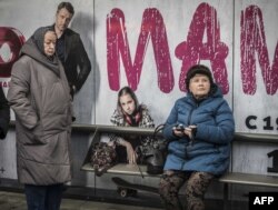 FILE - Two elderly women wait for their ride at a bus stop in Moscow, Nov. 1, 2018.