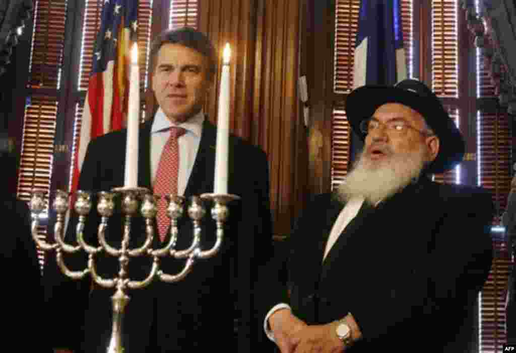 Rabbi Shimon Lazaroff, right and Texas Gov. Rick Perry take part in a symbolic menorah lighting ceremony on the second day of Hanukkah in Austin, Texas on Thursday, Dec. 2, 2010.(AP Photo/Jack Plunkett)