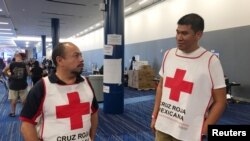 Marco Franco, left, deputy director of Mexican Red Cross disaster relief, talks with Gustavo Santillan, who is part of a group of 33 Mexican Red Cross volunteers helping at the George R. Brown convention center in Houston, Texas, Sept. 4, 2017.