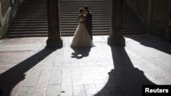 FILE - Jun Liu poses for a photo with his bride Seogyeong Choi during a wedding photoshoot at Bethesda Terrace in the Manhattan borough of New York, Oct. 20, 2015. 