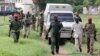 South Sudanese soldiers guard their colleagues, suspected of rape and murder, as they ride in a van before appearing in military in South Sudan's capital Juba, May 30, 2017.