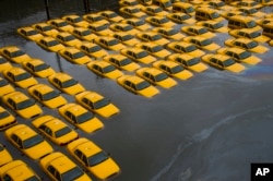 FILE - In this Tuesday, Oct. 30, 2012 file photo, a parking lot full of yellow cabs is flooded as a result of Superstorm Sandy in Hoboken, NJ. (AP Photo/Charles Sykes)