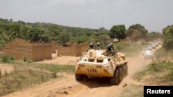 United Nations peacekeeping force vehicles drive by houses destroyed by violence in September, in the abandoned village of Yade, Central African Republic, April 27, 2017.