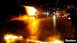 A police vehicle is set on fire by members of the Muslim Brotherhood and supporters of ousted Egyptian President Mohamed Morsi during clashes near a television production complex in Six October City in Giza, south of Cairo, August 2, 2013.