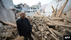 A man inspects a damaged building after an earthquake at Dahejia in Jishishan County in northwest China's Gansu province on Dec. 20, 2023.