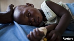 A young girl with malaria rests in the inpatient ward of the Malualkon Primary Health Care Center in Malualkon, in the South Sudanese state of Northern Bahr el-Ghazal, June 1, 2012. 