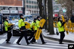 Polisi mengenakan masker, membawa barikade di Seoul, Korea Selatan, Kamis, 2 Desember 2021.
