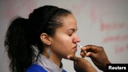 George Washington University student Laura Delgado is given the H1N1 flu nasal spray vaccine at the Student Health Service clinic in Washington November 19, 2009. REUTERS/Hyungwon Kang (UNITED STATES HEALTH)