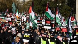 Protesters with placards and flags take part in the 'National March For Palestine' in central London on November 11, 2023, calling for a ceasefire in the conflict between Israel and Hamas.