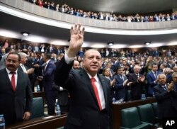 FILE - Turkey's President Recep Tayyip Erdogan gestures as he arrives to address the lawmakers of his ruling party in Ankara, Turkey, Oct. 24, 2017. Erdogan said an operation to implement a "de-escalation" zone in Syria's northern Idlib province is "to a great extent complete."