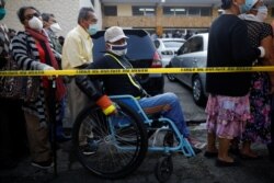 Un hombre hace fila frente al Centro Nacional de Cuidados y Administración de Subsidios (CENADE) para averiguar si es elegible para ayuda económica en San Salvador.