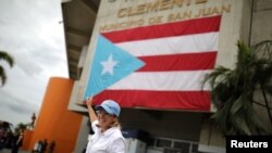 Alcaldesa de San Juan, Puerto Rico, ondeando la bandera de la isla.