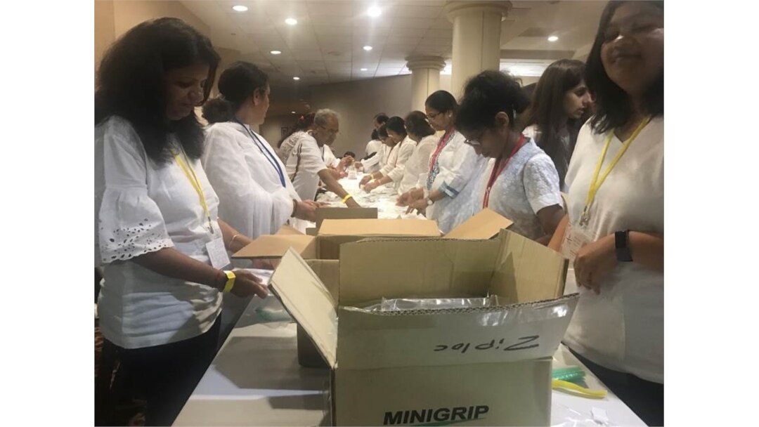 Volunteers of all ages pack hygiene kits for local homeless at long, narrow assembly lines. (Photo: Leslie Bonilla/VOA)
