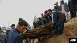FILE - Mourners carry a covered body during a burial ceremony following a suicide attack on a hospital, at a cemetery in Kabul, Afghanistan, May 13, 2020. 