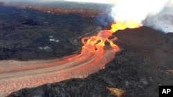 In this Sunday, June 10, 2018 photo from the U.S. Geological Survey, fissure 8 below Kilauea Volcano continues to erupt vigorously with lava streaming through a channel that reaches the ocean at Kapoho Bay on the island of Hawaii.