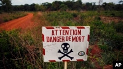 FILE - In this April 11, 2014, picture, a sign warns travelers of the dangers ahead on the road to Bambari, Central African Republic. According to a Human Rights Watch report released on May 2, 2017, armed groups targeting civilians have killed at least 45 people and displaced thousands in recent months. 