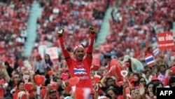 Thai pro-government Red Shirt supporters wave clappers and cheer leaders' speeches during a rally at a stadium in Bangkok, Nov. 30, 2013.