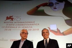 Venice Film Festival director Alberto Barbera, right, and Paolo Baratta, president of the arts organization Venice Biennale, pose for photographers on the occasion of the official presentation of the 75th edition of the festival in Rome, July 25, 2018. The Venice Film Festival will run from Aug. 29 through Sept. 8 at the Venice Lido.