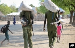 Rebel fighters walk through town after receiving food in Akobo, near the Ethiopian border, in South Sudan, Jan. 19, 2018.