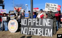 FILE - Demonstrators opposing the Keystone XL oil pipeline hold banners in Omaha, Neb., Jan. 13, 2015.