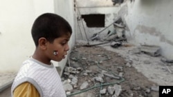 A Libyan child stands in a house damaged by a rocket supposedly fired by pro-Gadhafi forces and which injured four people in Misrata, Libya (File Photo - June 21, 2011)