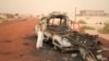 A man takes a close look at a burned-out truck in Timbuktu, Mali, January 31, 2013. 