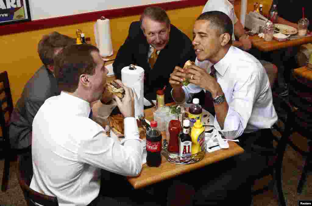 Le président russe Dmitry Medvedev, à gauche, et le président américain Barack Obama, partagent un hamburger à Ray's Hell Burger, à Arlington, Virginie, 24 juin 2010.
