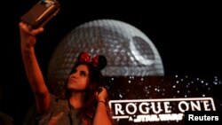 A guest takes a selfie as the Spaceship Earth is turned into the Death Star via projectors in advance of the release of the new Star Wars movie "Rogue One," at the Walt Disney World's Epcot Center in Lake Buena Vista, Florida, Dec. 5, 2016. 