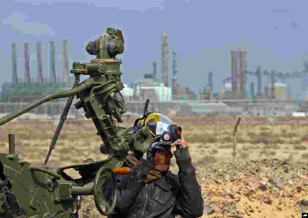 A rebel mans an antiaircraft weapon in front of a refinery in Ras Lanuf, March 8, 2011