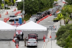 Vehicles wait in line at a COVID-19 testing site at the Miami Beach Convention Center, Florida, July 12, 2020.