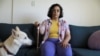 FILE - Leticia de Souza Soares, who suffers from pain and health problems caused by long COVID-19, holds a cane while sitting at home, in Salvador, Brazil, Dec. 8, 2023.