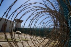 Menara kontrol terlihat melalui kawat berduri di Pangkalan Angkatan Laut Teluk Guantanamo, di Kuba, 17 April 2019. (Foto AP / Alex Brandon, File)