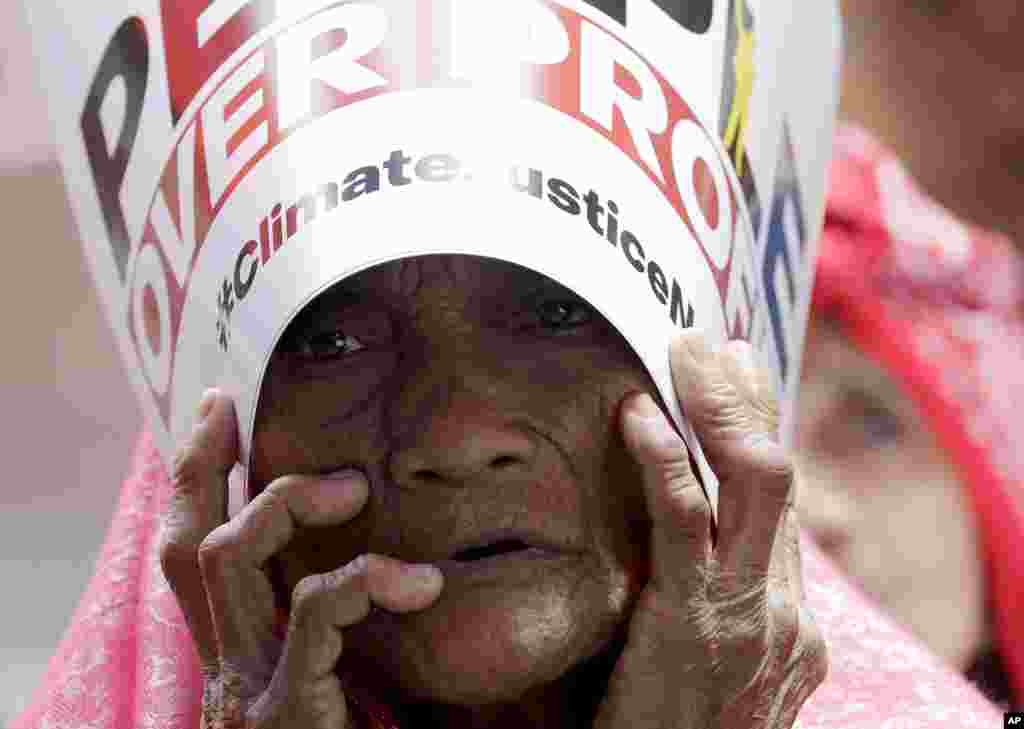 An environmental activist holds a placard during a rally outside the Department of Environment and Natural Resources at suburban Quezon city, northeast of Manila, Philippines.