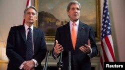 Menteri Luar Negeri AS John Kerry dan Menteri Luar Negeri Inggris Phillip Hammond (kiri) dalam konferensi pers di London (21/2). (Reuters/Neil Hall)