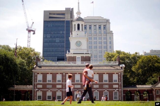 FILE - People move past Independence Hall at the Independence National Historical Park in Philadelphia, Thursday, Aug. 25, 2016. Thursday marks the 100th anniversary of the National Park Service. (AP Photo/Matt Rourke)