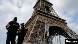 FILE - French police patrol near the Eiffel tower as part of security measures in Paris, France, July 13, 2017. 