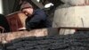 A worker stacks coal briquettes at a coal distribution business in Huaibei, central China's Anhui province, January 30, 2013. 