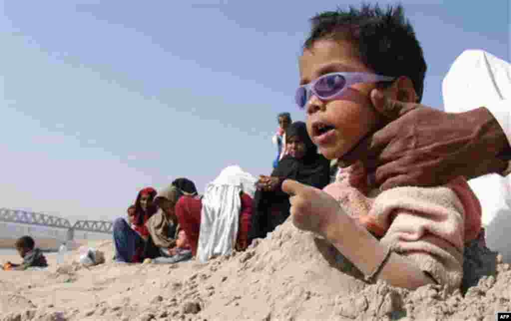 Pakistani familes bury their children during the partial solar eclipse in Hyderabad, Pakistan on Tuesday, Jan. 4, 2011. Superstitious people hope that burying ailing person during solar eclipse will cure them. (AP Photo/Pervez Masih)