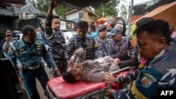 Rescue personnel transport a survivor from the site of a landslide triggered by heavy rains to a hospital in Mudal village, near Pekalongan city in Central Java, on Jan. 22, 2025.