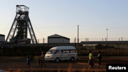 Members of the mining community walk past the Doornkop Gold Mine, about 30 km (19 miles) west of Johannesburg, September 3, 2013. 