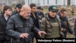 Penuntut dari Mahkamah Kriminal Internasional (ICC) Karim Khan (kiri) didampingi Jaksa Agung Ukraina Iryna Venediktova mengunjungi kuburan massal di Bucha, pinggiran Kyiv, Ukraina hari Rabu (14/4). 