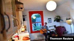 El músico Theo Bard canta mientras realiza una transmisión virtual desde la cocina de su casa en Londres, Inglaterra.